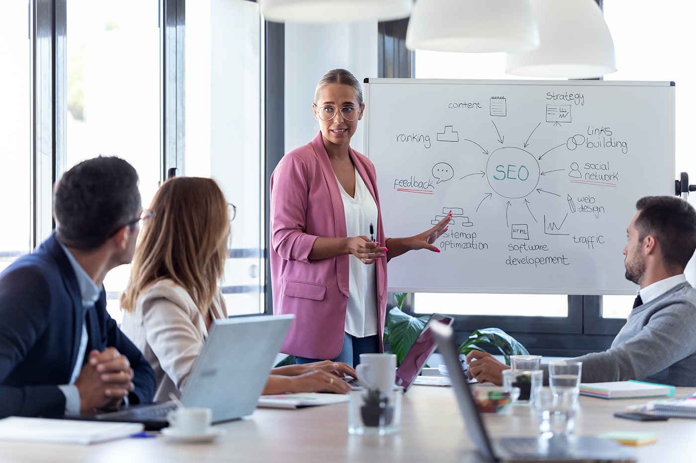 young-businesswoman-pointing-at-white-blackboard-a-NU2N2WV.jpg